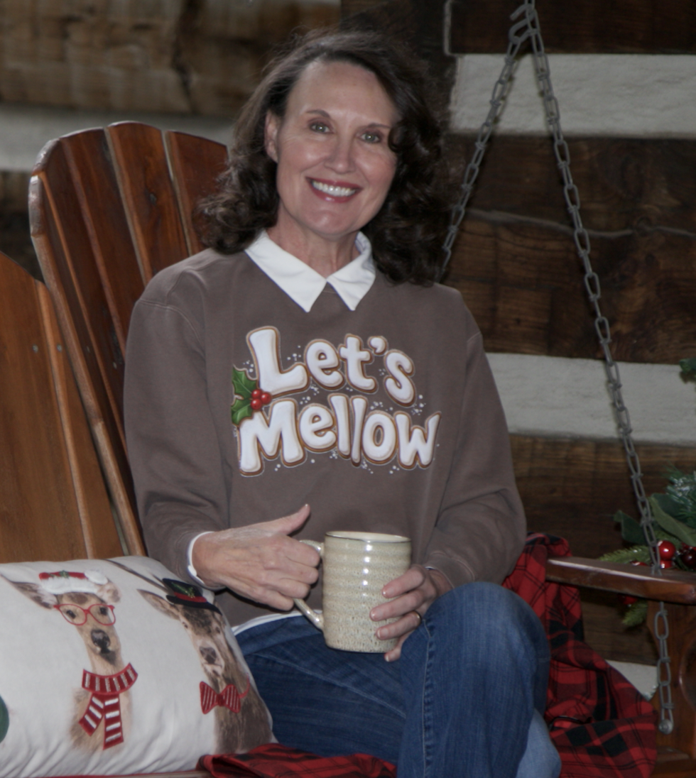 Cindy May seated on the cabin porch swing